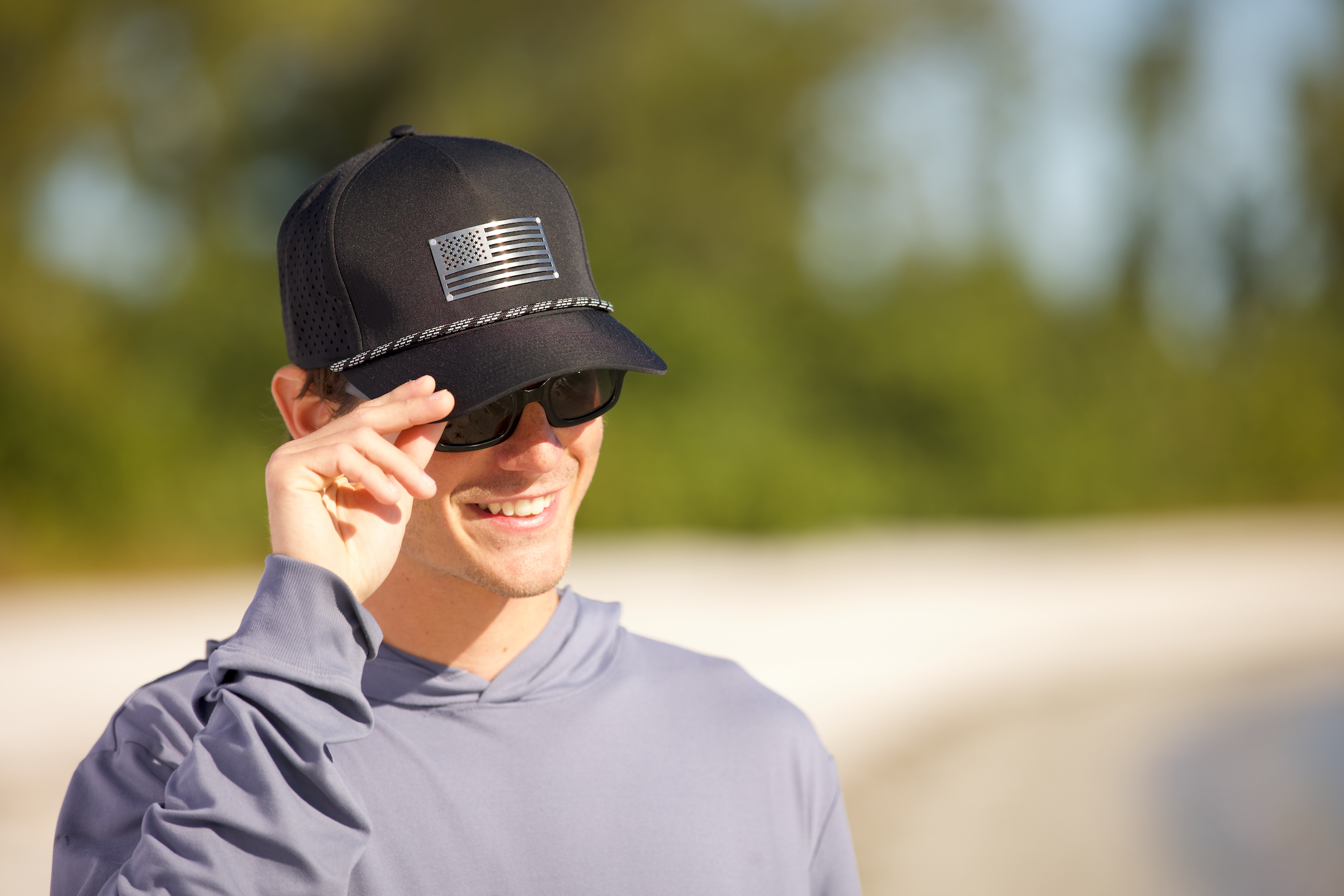 Man wearing a black cap with an American flag design outdoors